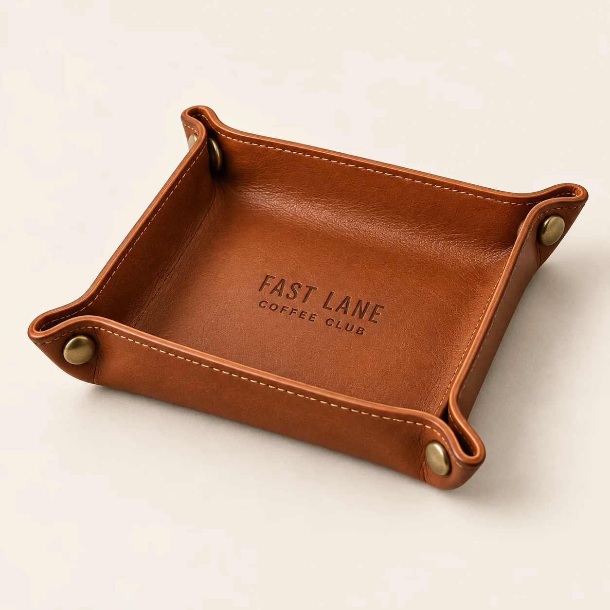 Vide-poche carré cognac à coins relevés, signé Le Cercle du Volant.